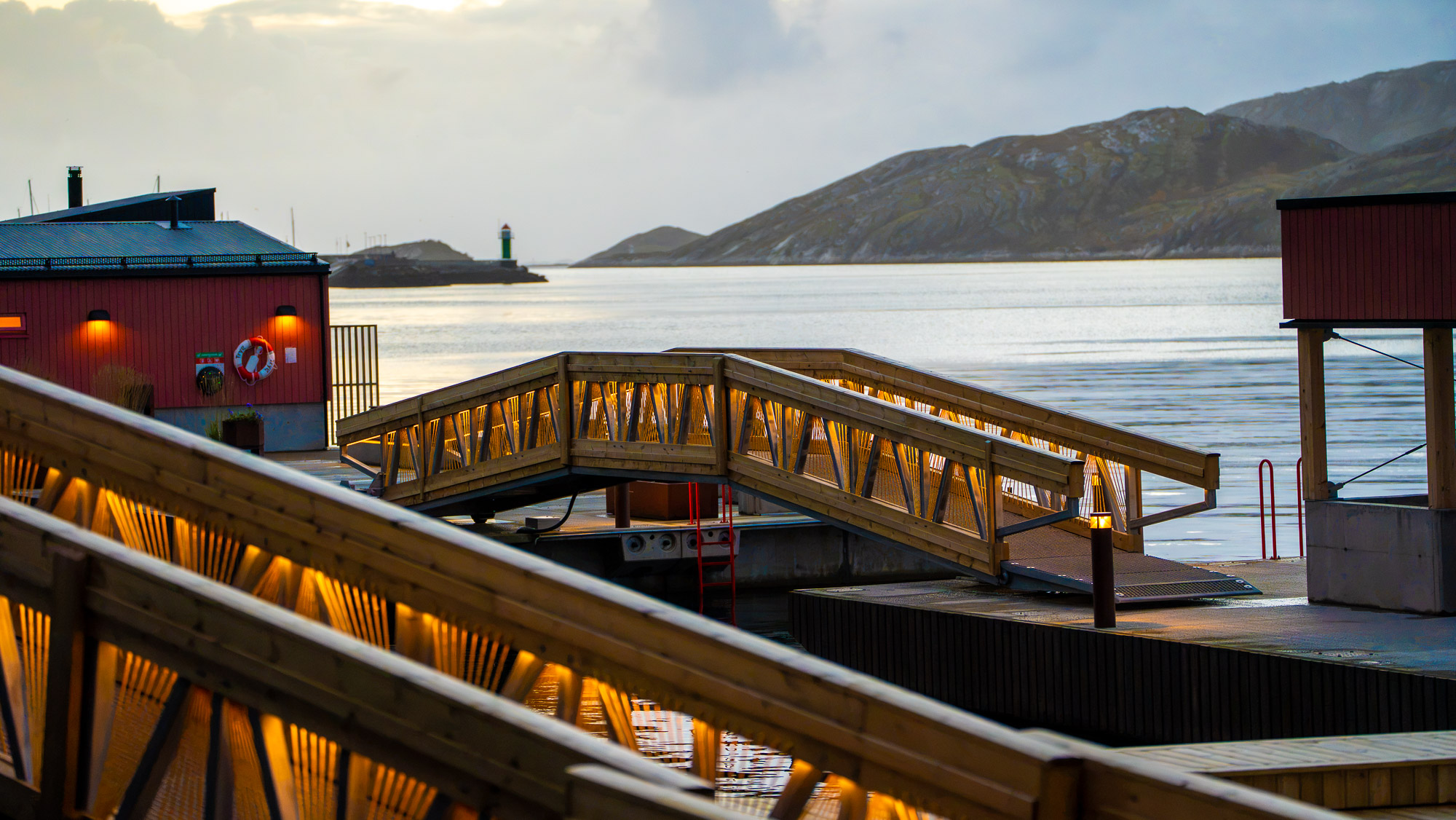 Two Sunweave gangways seen from the quay, with fjord and mountains behind